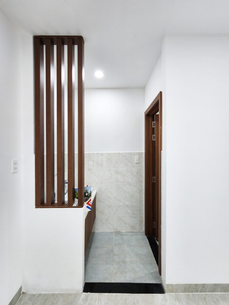 nhà vệ sinh kh vực tầng trệt sửa dụng lam gỗ làm vách ngăn độc đáo. 