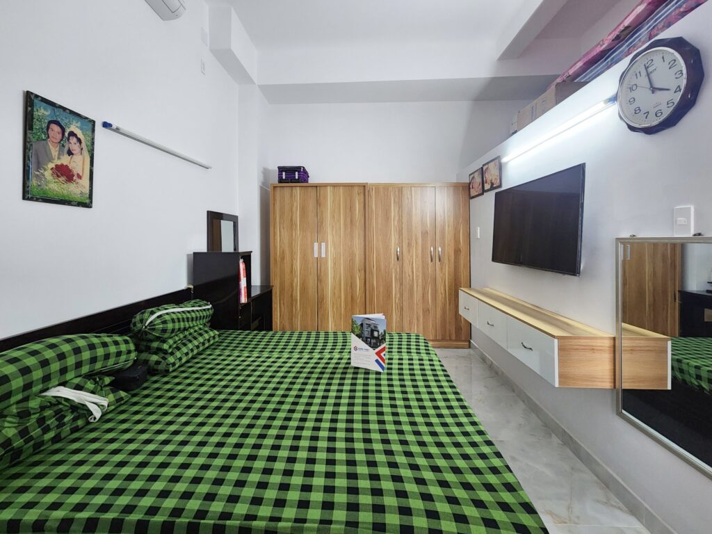 Phòng ngủ tại tầng trệt được bày trí nội thất gỗ màu sẫm phù hợp với nét truyền thống 