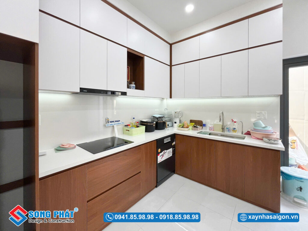 Không gian bếp chữ L gọn gàng, tủ kịch trần trắng – gỗ hài hòa, vừa đẹp mắt vừa tối ưu công năng